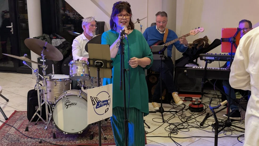 Zangeres met big band op verlicht podium